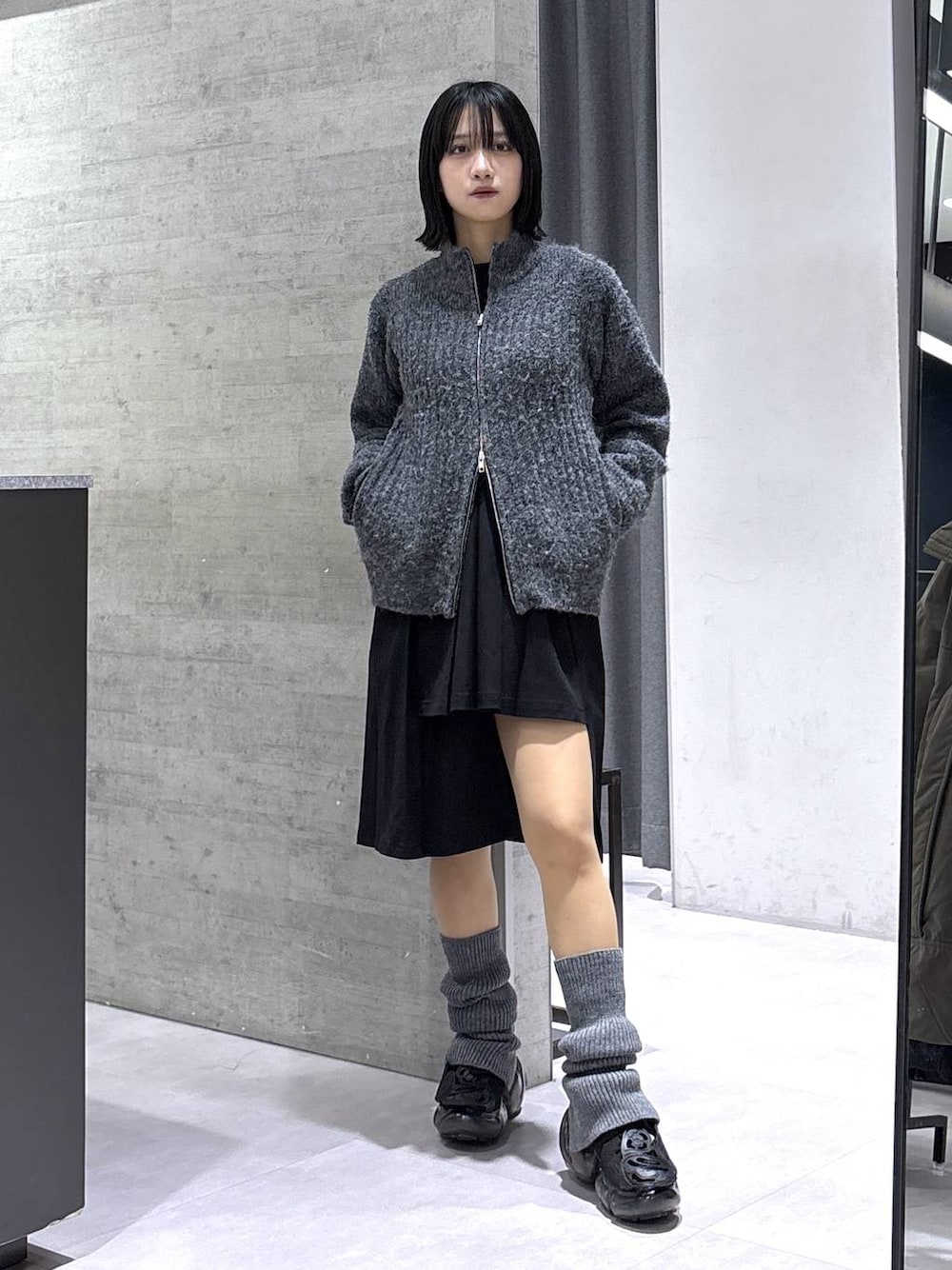 ブラック系のスカート、グレー系のカーディガン/ボレロ、ブラック系のベルトを着用したレディースの冬コーディネートの1枚目の写真