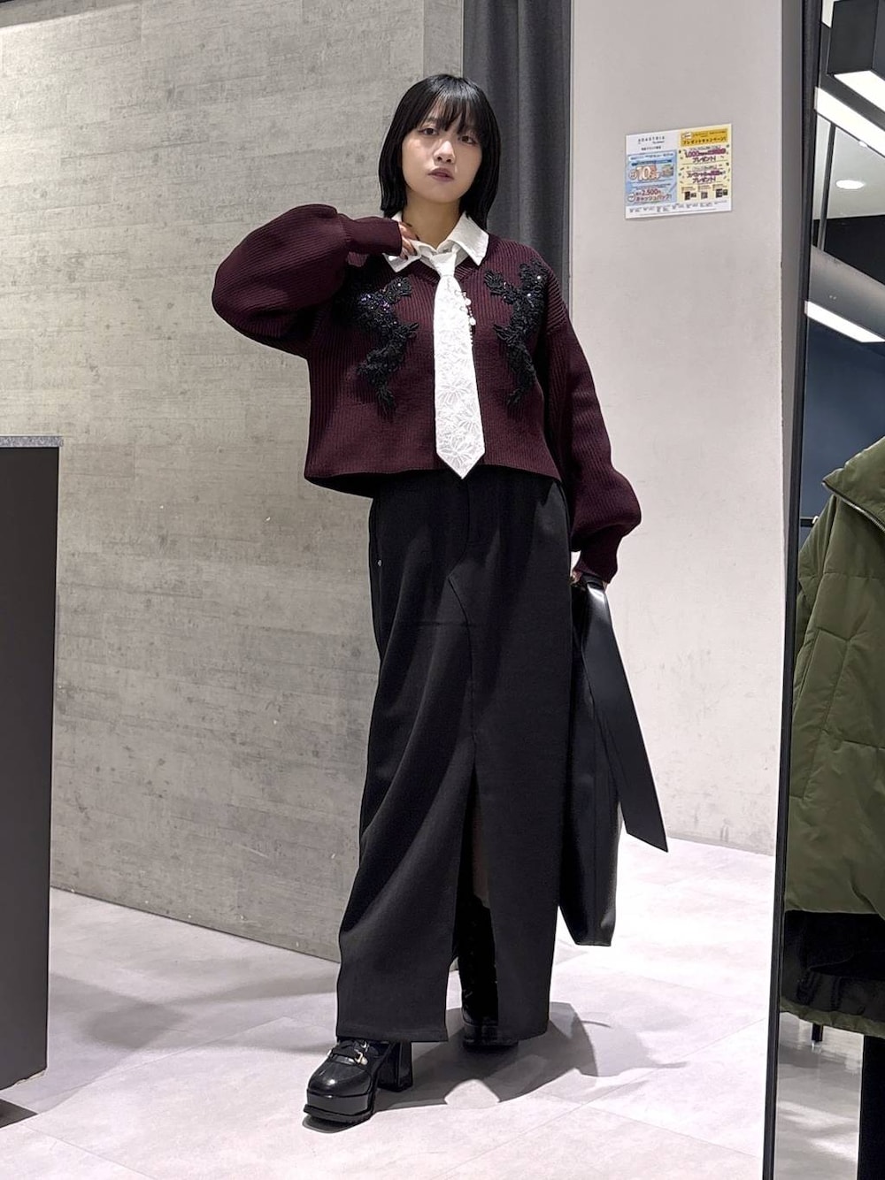 ブラック系のトートバッグ、ブラック系のブーツ、レッド系のニット/セーターを着用したレディースの秋コーディネートの1枚目の写真