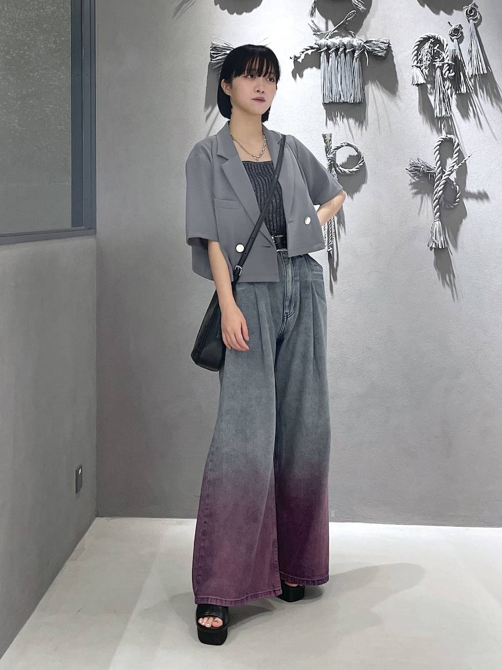 ブラック系のタンクトップ、ブラック系のサンダル、パープル系のデニムパンツを着用したレディースの夏コーディネートの1枚目の写真