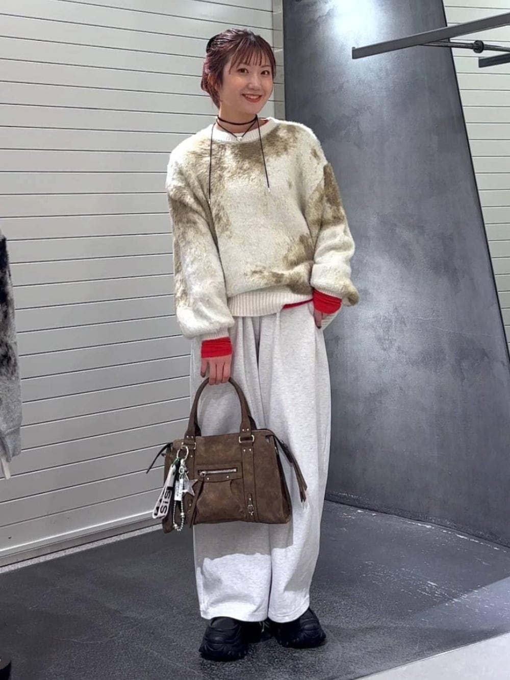 ホワイト系のニット/セーター、ブラウン系のボストンバッグ、ブラック系のローファーを着用したレディースの冬コーディネートの1枚目の写真