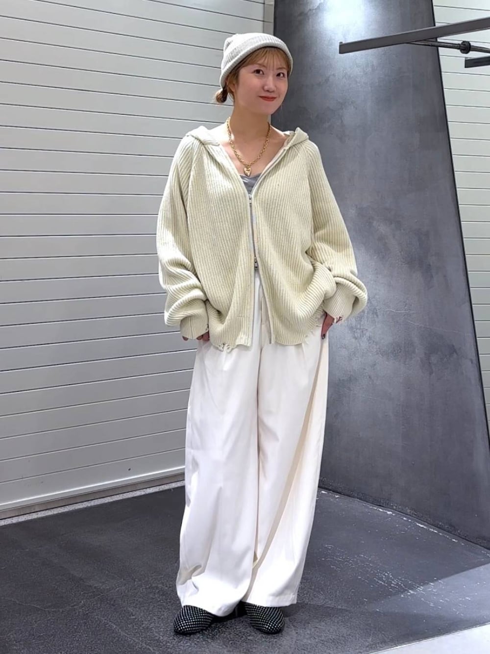 ブラック系のパンプス、ホワイト系のスラックス、ホワイト系のパーカーを着用したレディースの秋コーディネートの1枚目の写真
