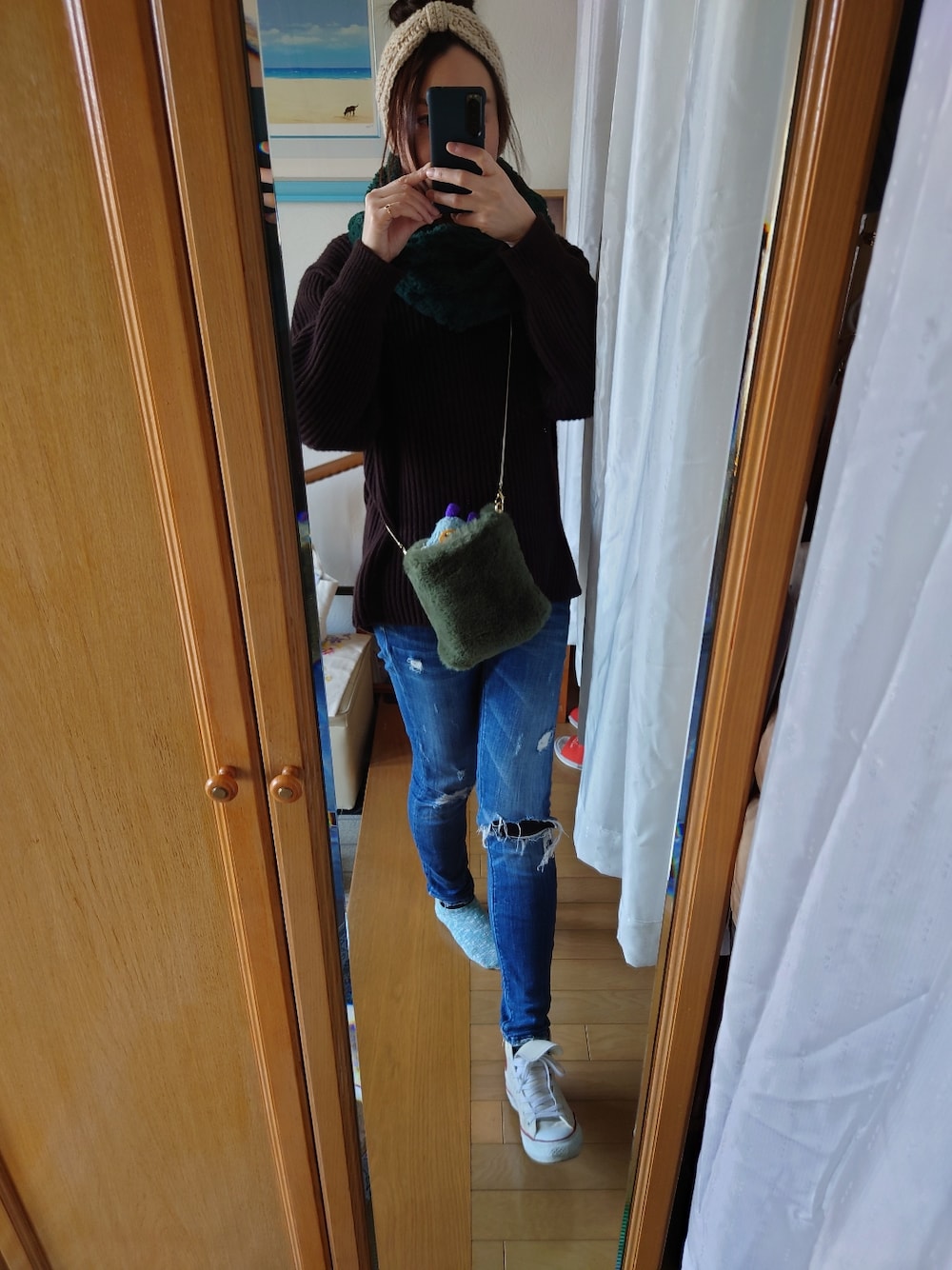 ブルー系のデニムパンツ、ブラウン系のニット/セーター、ホワイト系のヘアバンドを着用したレディースの冬コーディネートの3枚目の写真