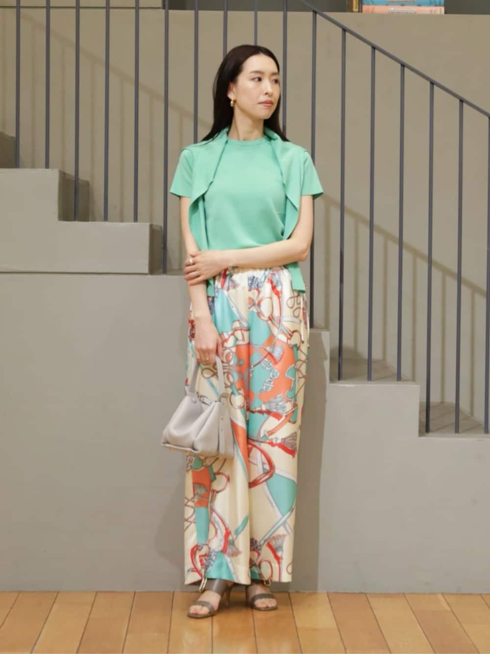 グリーン系のカーディガン/ボレロ、グリーン系のニット/セーター、グレー系のハンドバッグを着用したレディースの春コーディネートの1枚目の写真