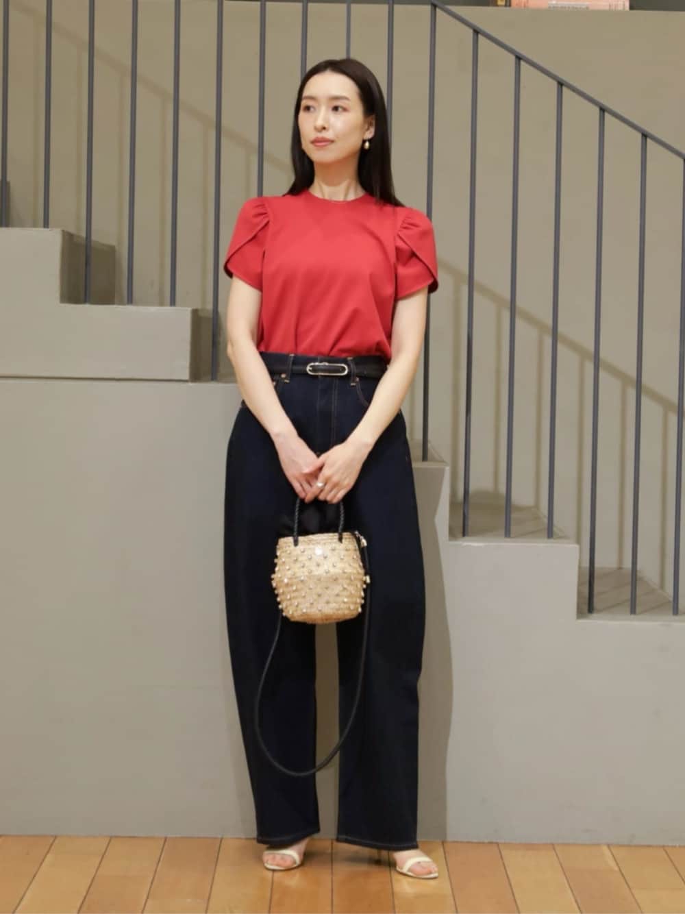 レッド系のTシャツ/カットソー、ブルー系のデニムパンツ、ブラック系のかごバッグを着用したレディースの春コーディネートの1枚目の写真