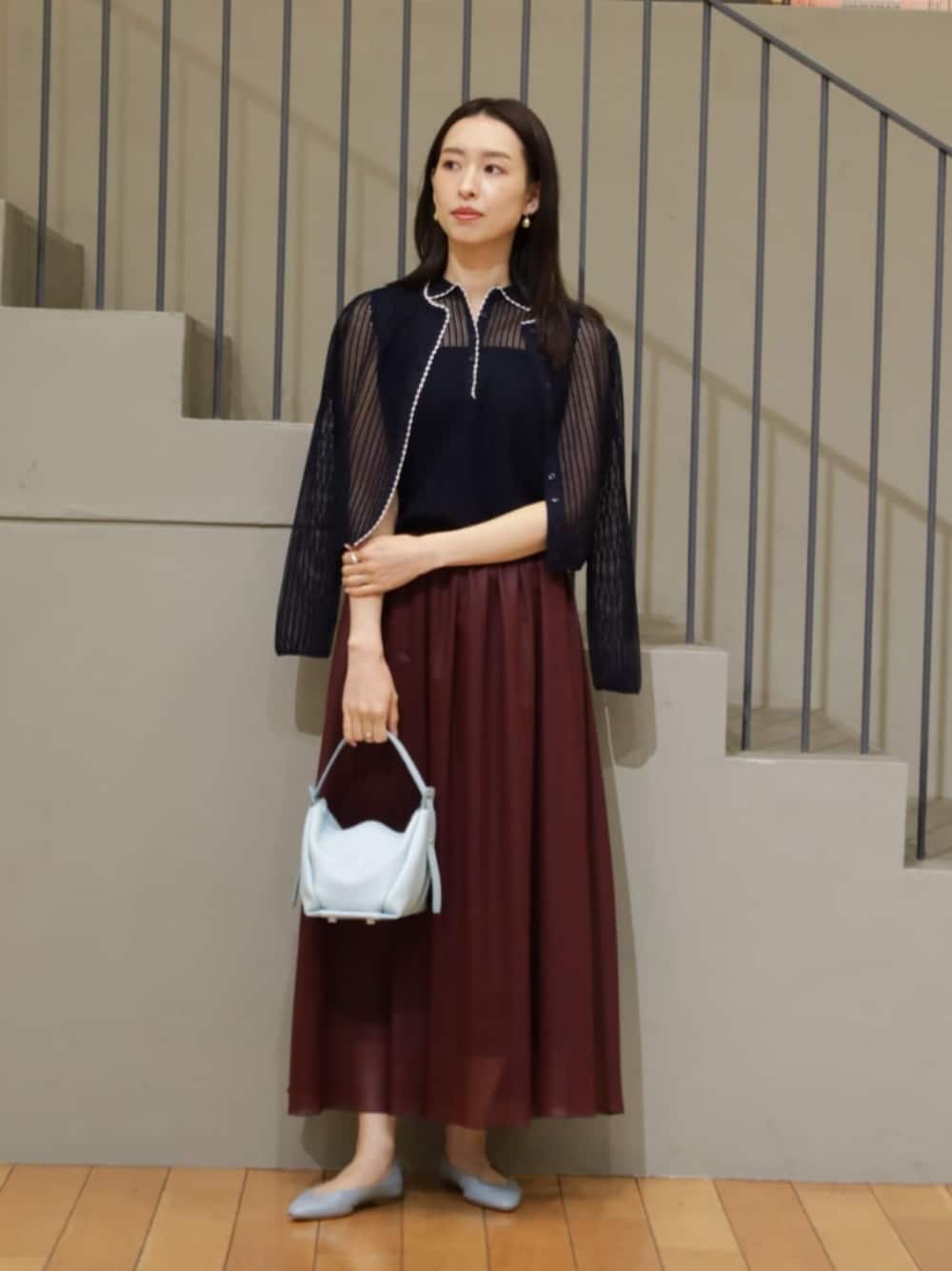 ブルー系のカーディガン/ボレロ、ブルー系のニット/セーター、レッド系のスカートを着用したレディースの夏コーディネートの1枚目の写真