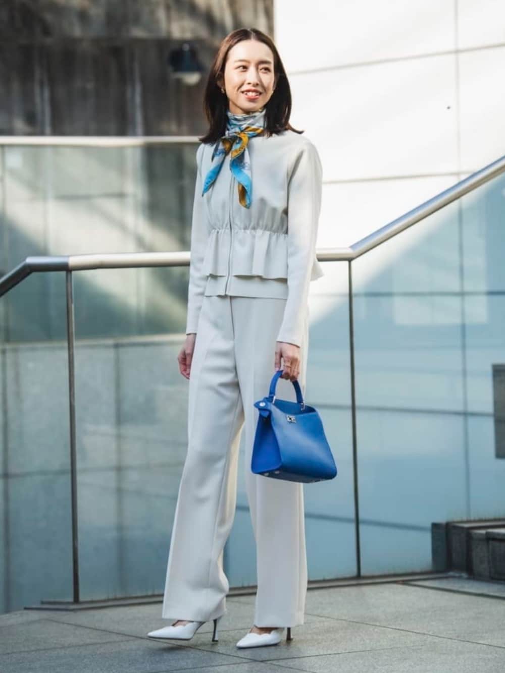 ホワイト系のカーディガン/ボレロ、ベージュ系のスラックス、ブルー系のバンダナ/スカーフを着用したレディースの冬コーディネートの1枚目の写真