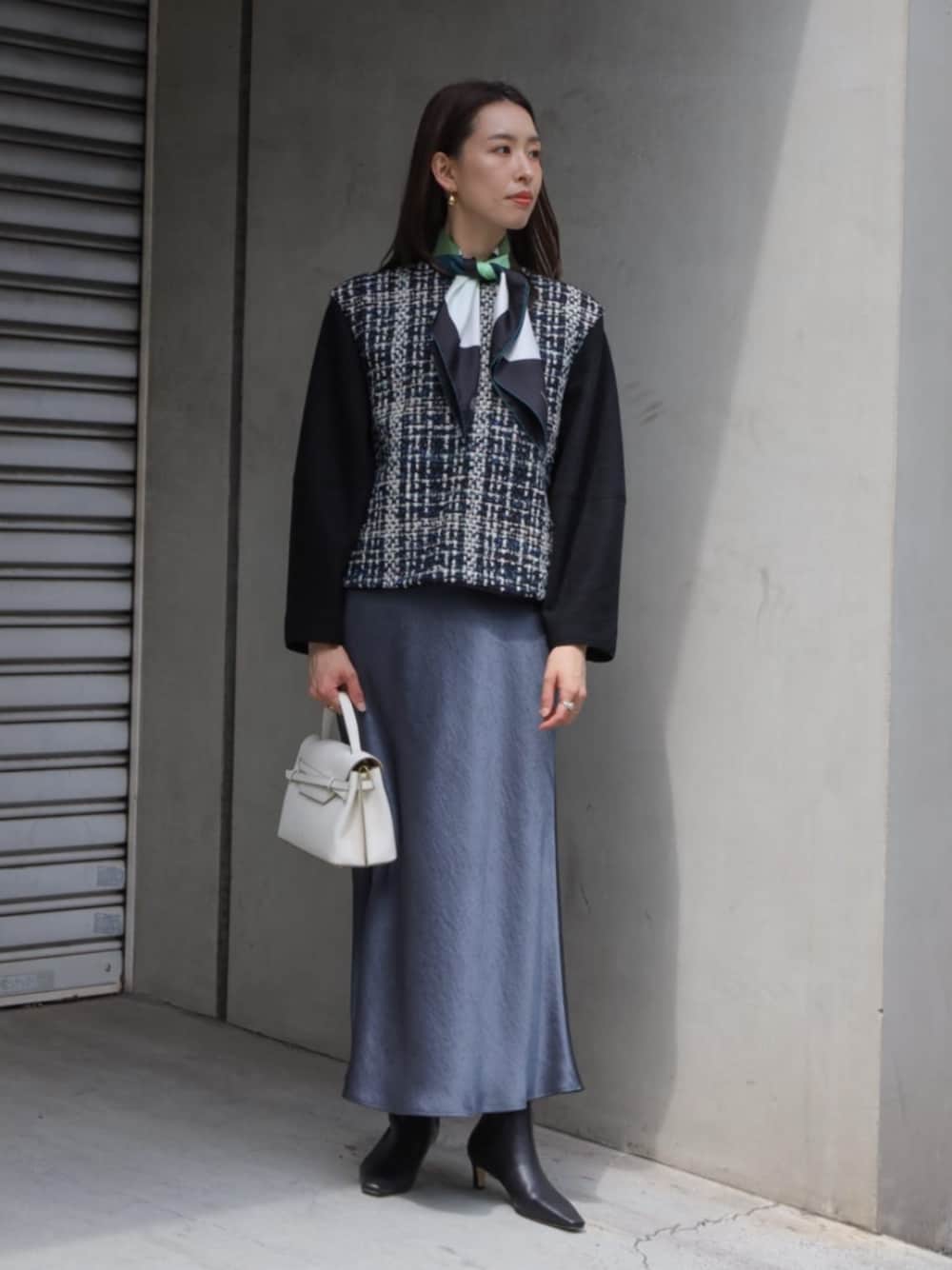 ブラック系のその他トップス、ブラック系のブーツ、ホワイト系のハンドバッグを着用したレディースの秋コーディネートの1枚目の写真