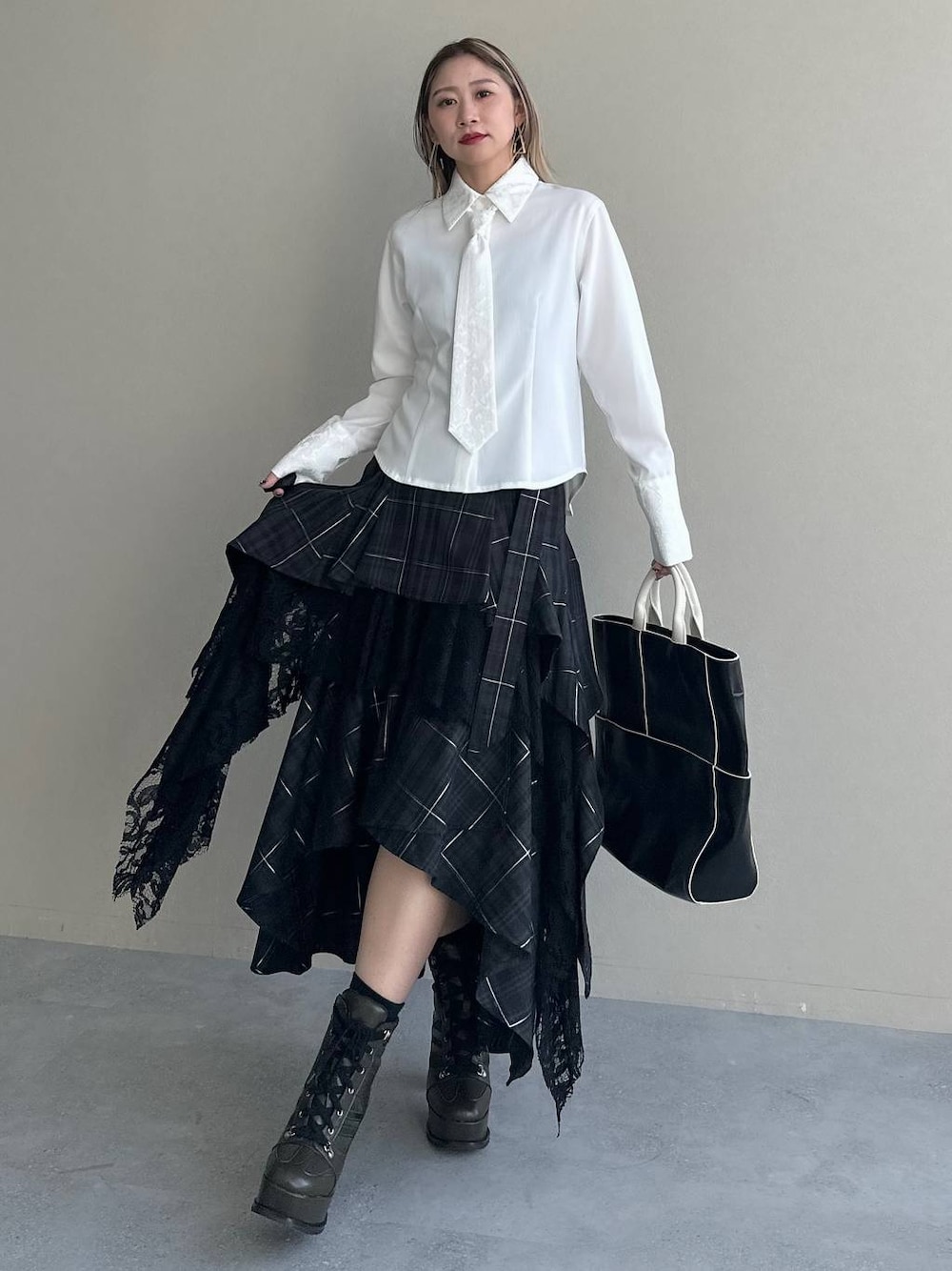 ブラック系のショルダーバッグ、ブラック系のスカート、ホワイト系のシャツ/ブラウスを着用したレディースの夏コーディネートの1枚目の写真