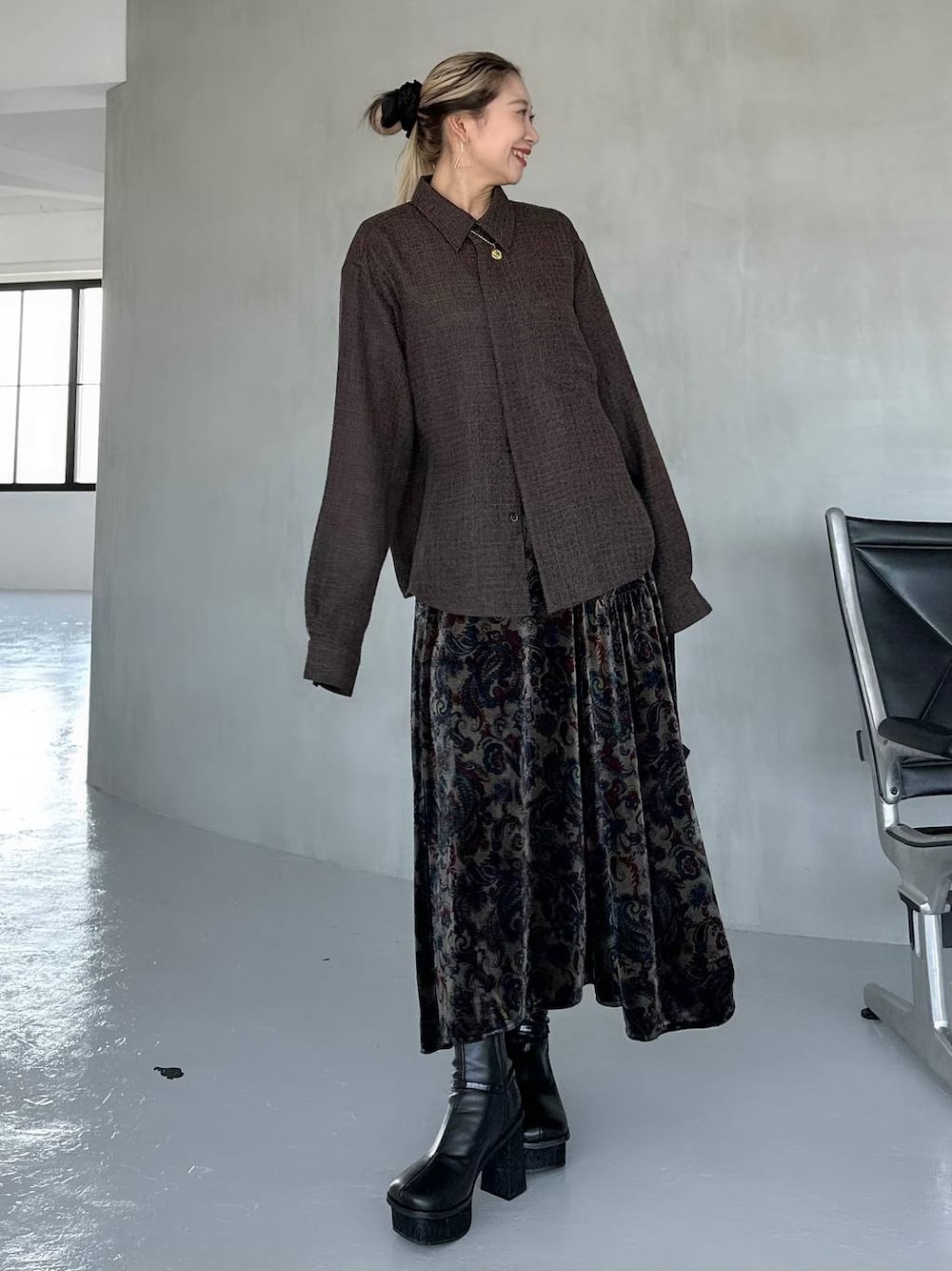 ブラック系のスカート、ブラック系のブーツ、ブラウン系のシャツ/ブラウスを着用したレディースの秋コーディネートの1枚目の写真