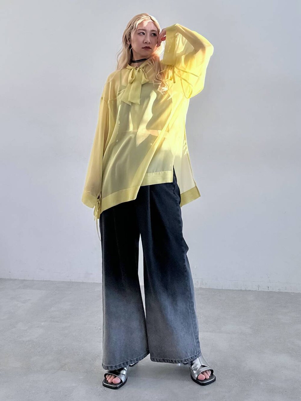 シルバー系のサンダル、ブラック系のデニムパンツ、イエロー系のTシャツ/カットソーを着用したレディースの春コーディネートの1枚目の写真