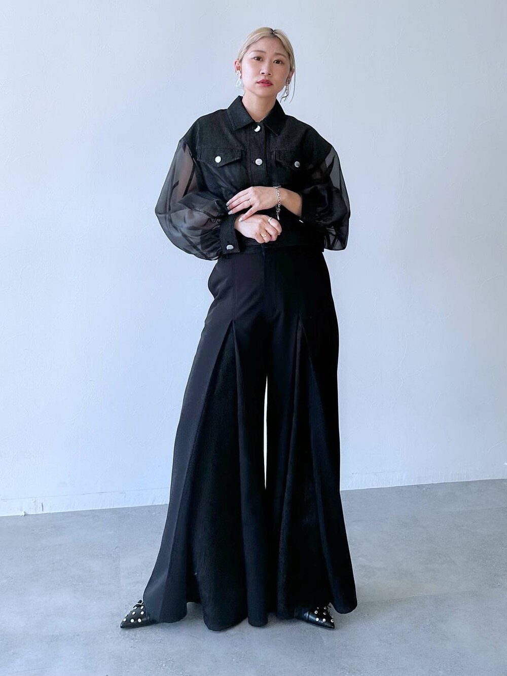 ブラック系のスラックス、ブラック系のパンプス、ブラック系のブルゾンを着用したレディースの夏コーディネートの1枚目の写真