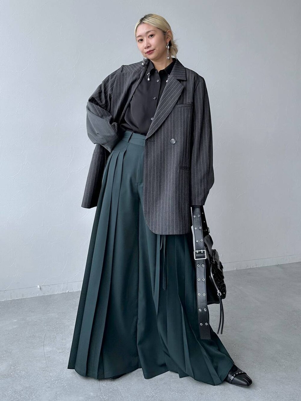 ブラック系のバレエシューズ、ブラック系のショルダーバッグ、グリーン系のその他パンツを着用したレディースの秋コーディネートの1枚目の写真