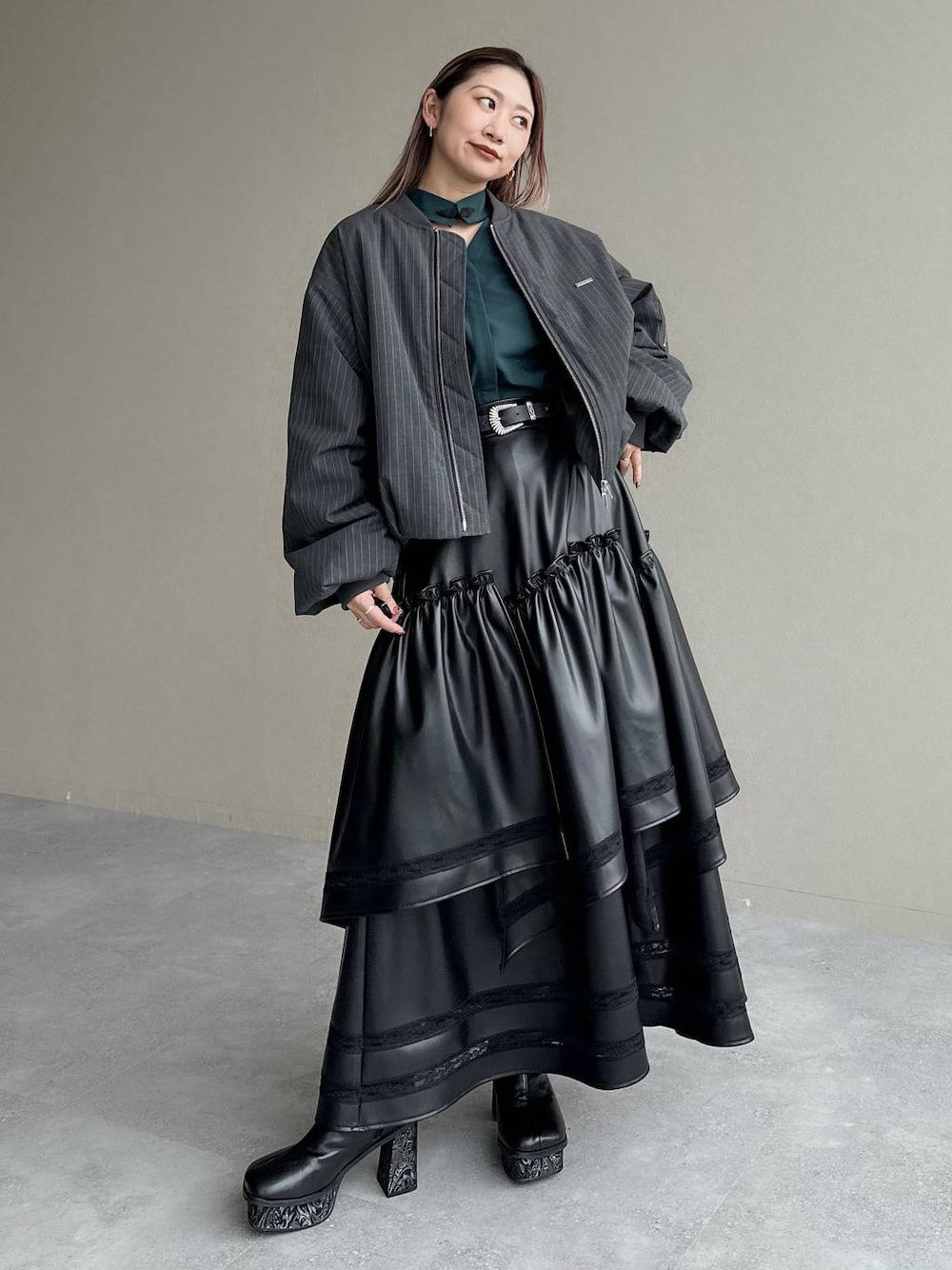 グレー系のブーツ、ブラック系のスカート、グリーン系のシャツ/ブラウスを着用したレディースの秋コーディネートの1枚目の写真