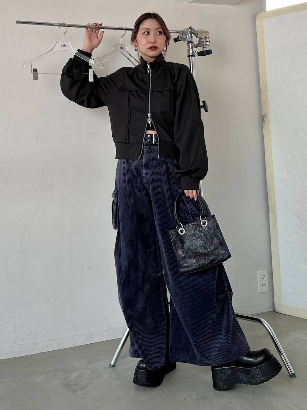 ブラック系のショルダーバッグ、ブルー系のパーカー、ブルー系のカーゴパンツを着用したレディースの秋コーディネートの1枚目の写真