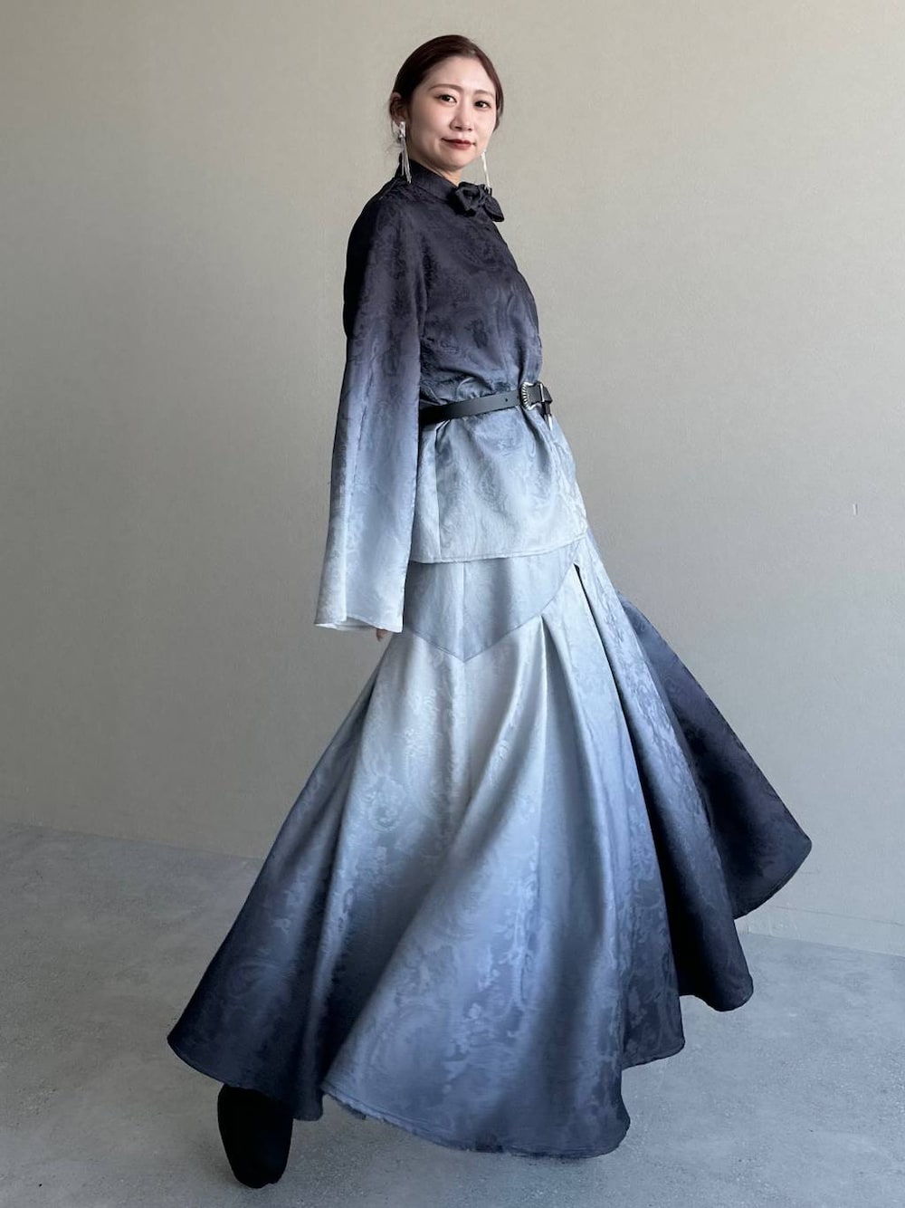 ブラック系のブーツ、ブラック系のシャツ/ブラウス、ブラック系のスカートを着用したレディースの冬コーディネートの1枚目の写真