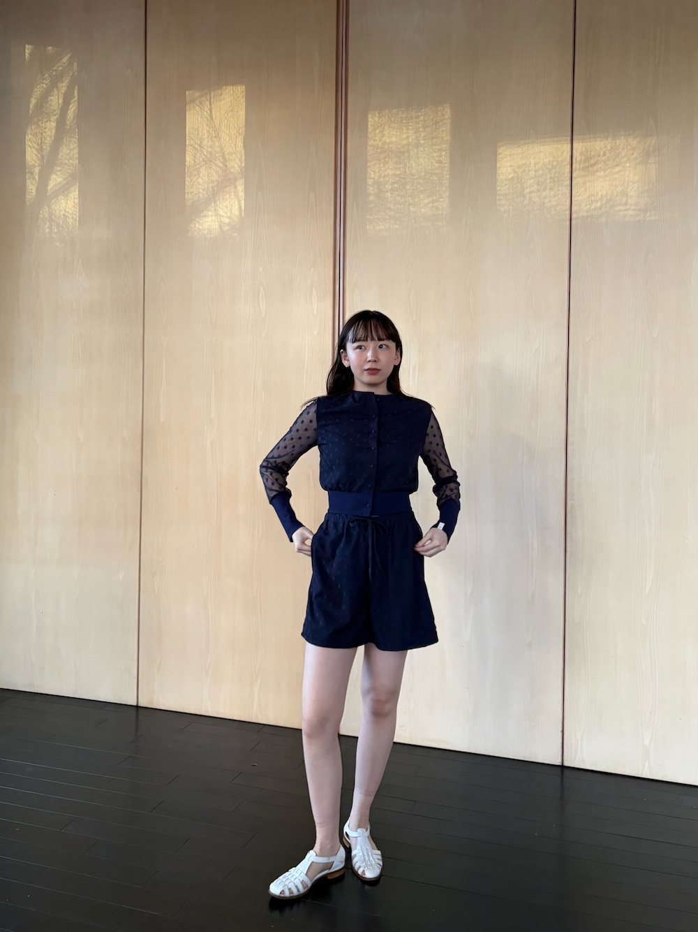 ブルー系のパンツ、ホワイト系のサンダルを着用したレディースの春コーディネートの1枚目の写真
