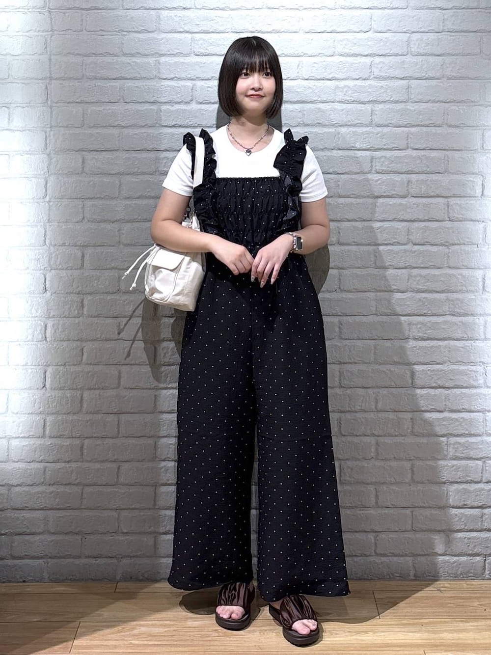 ホワイト系のTシャツ/カットソー、ブラウン系のサンダル、ホワイト系のショルダーバッグを着用したレディースの夏コーディネートの1枚目の写真