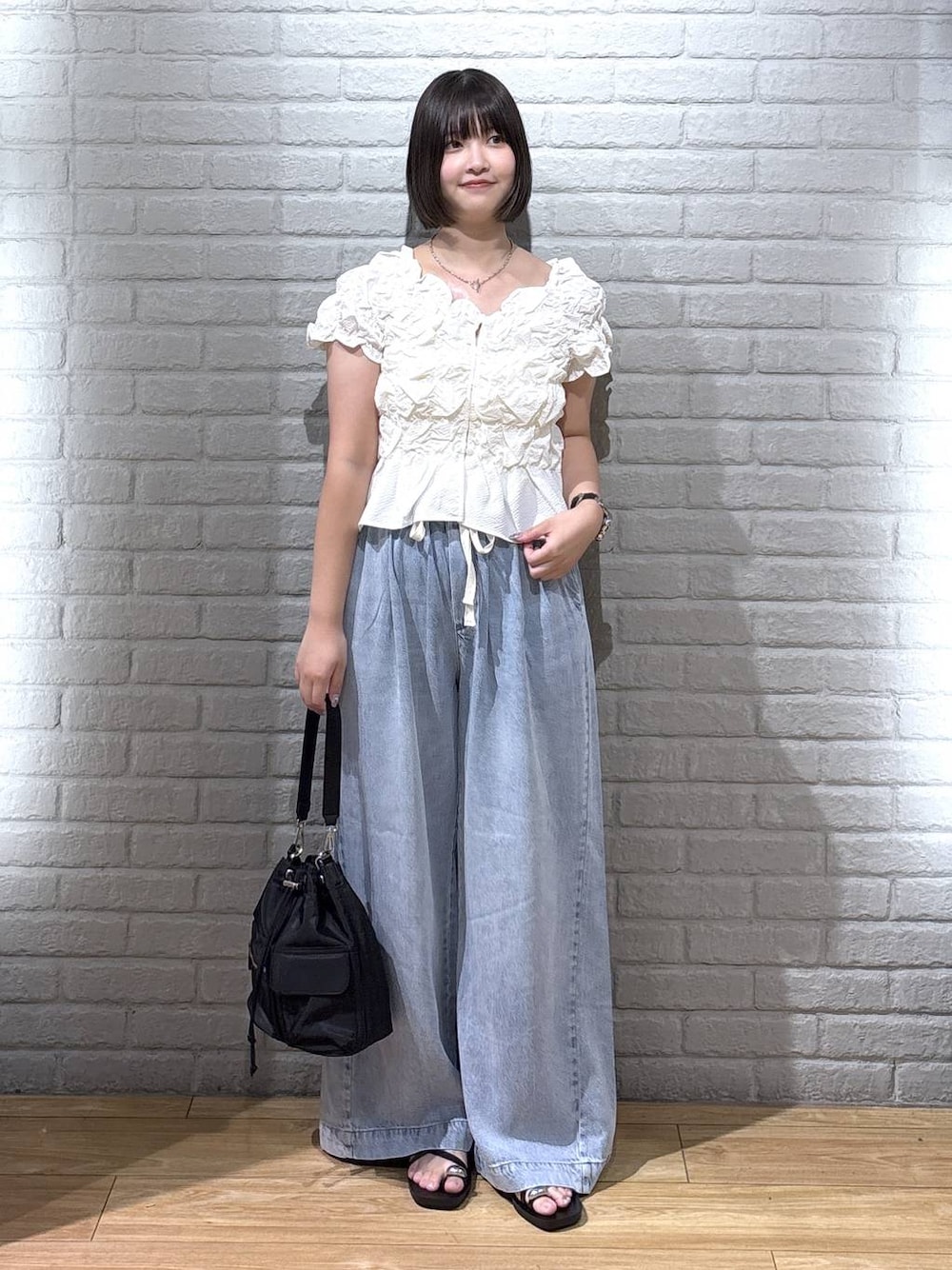 ホワイト系のシャツ/ブラウス、ブルー系のデニムパンツ、ブラック系のサンダルを着用したレディースの夏コーディネートの1枚目の写真