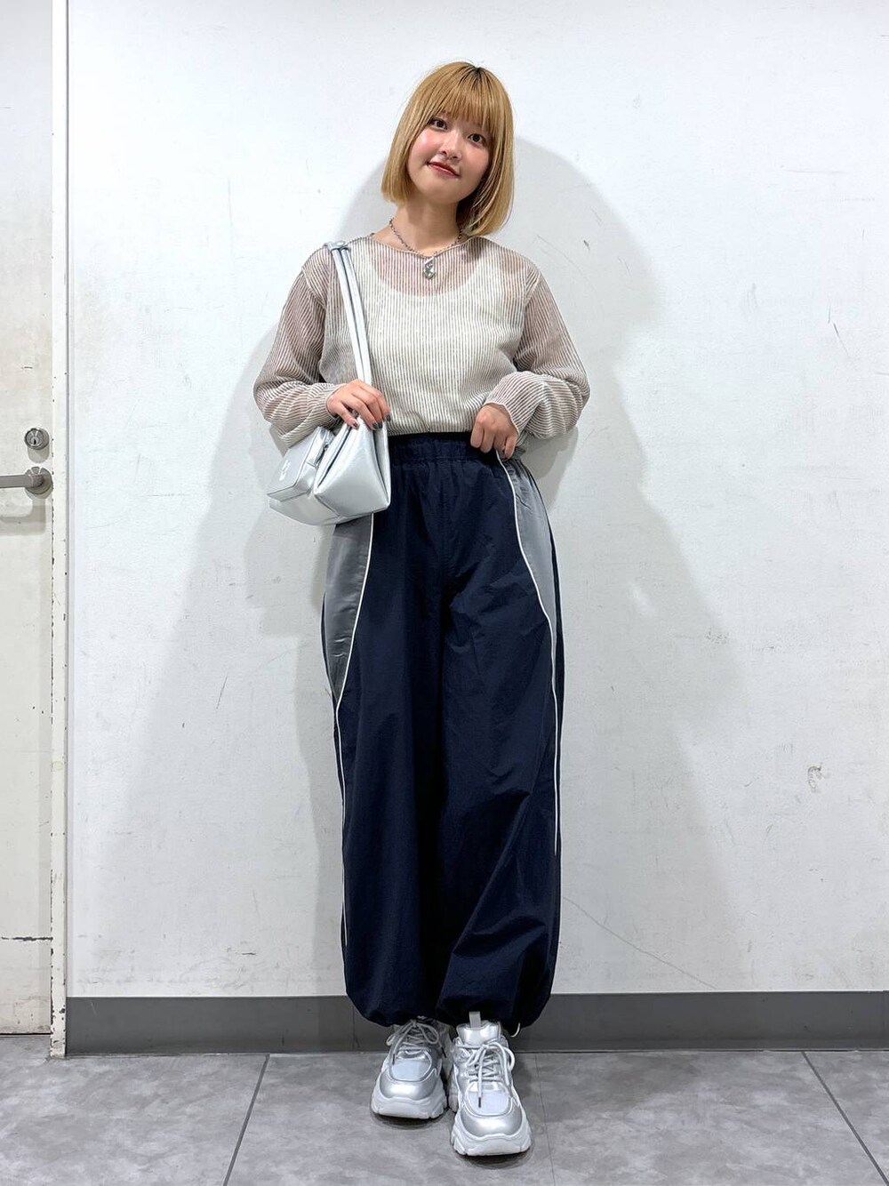 ブルー系のカーゴパンツ、シルバー系のショルダーバッグ、ホワイト系のタンクトップを着用したレディースの夏コーディネートの1枚目の写真