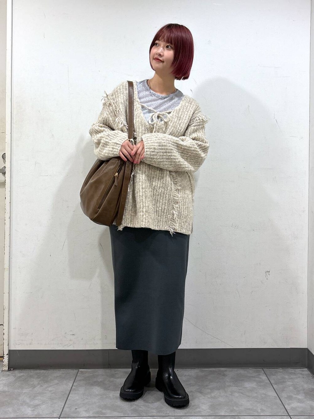ホワイト系のニット/セーター、シルバー系のTシャツ/カットソー、ブラック系のブーツを着用したレディースの秋コーディネートの1枚目の写真