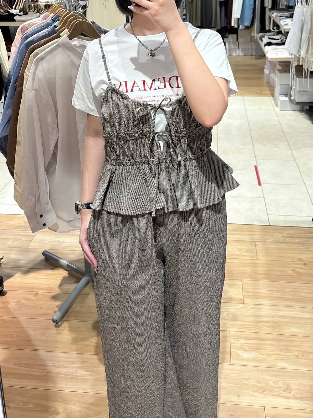 ブラック系のパンプス、ホワイト系のTシャツ/カットソー、ブラウン系のサロペット/オーバーオールを着用したレディースの春コーディネートの1枚目の写真