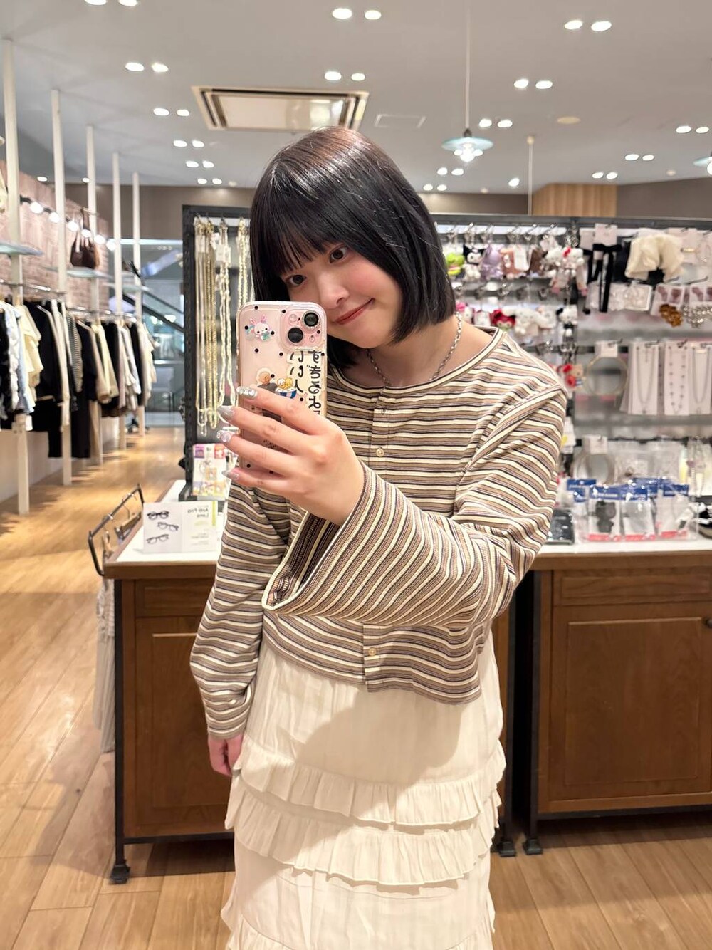 ブラウン系のローファー、ホワイト系のスカート、ベージュ系のカーディガン/ボレロを着用したレディースの春コーディネートの1枚目の写真