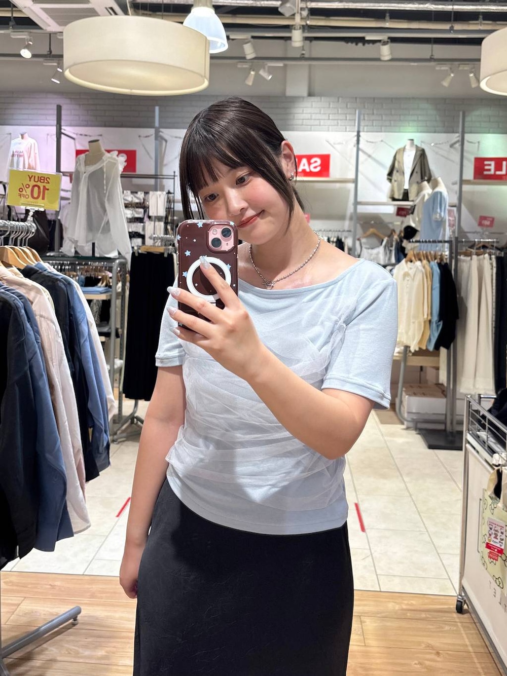 ブルー系のTシャツ/カットソー、ブラック系のスカート、ブラック系のサンダルを着用したレディースの夏コーディネートの1枚目の写真