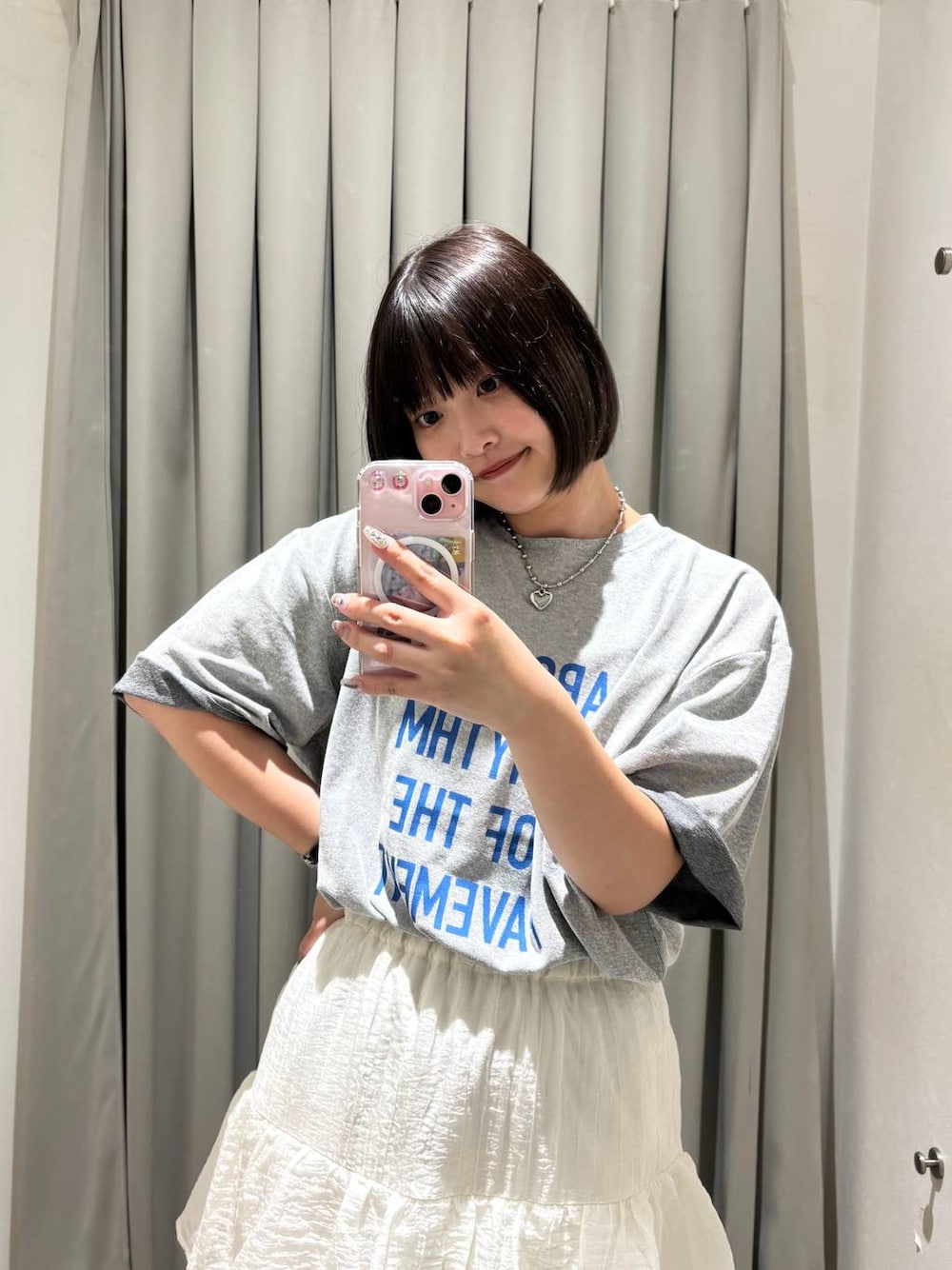 グレー系のTシャツ/カットソー、ホワイト系のスカートを着用したレディースの夏コーディネートの1枚目の写真
