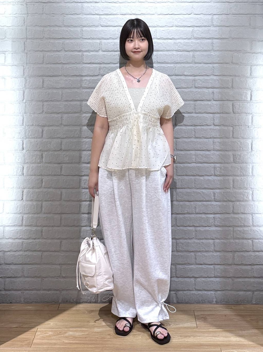 グレー系のスウェットパンツ、ゴールド系のタンクトップ、ブラック系のサンダルを着用したレディースの夏コーディネートの1枚目の写真