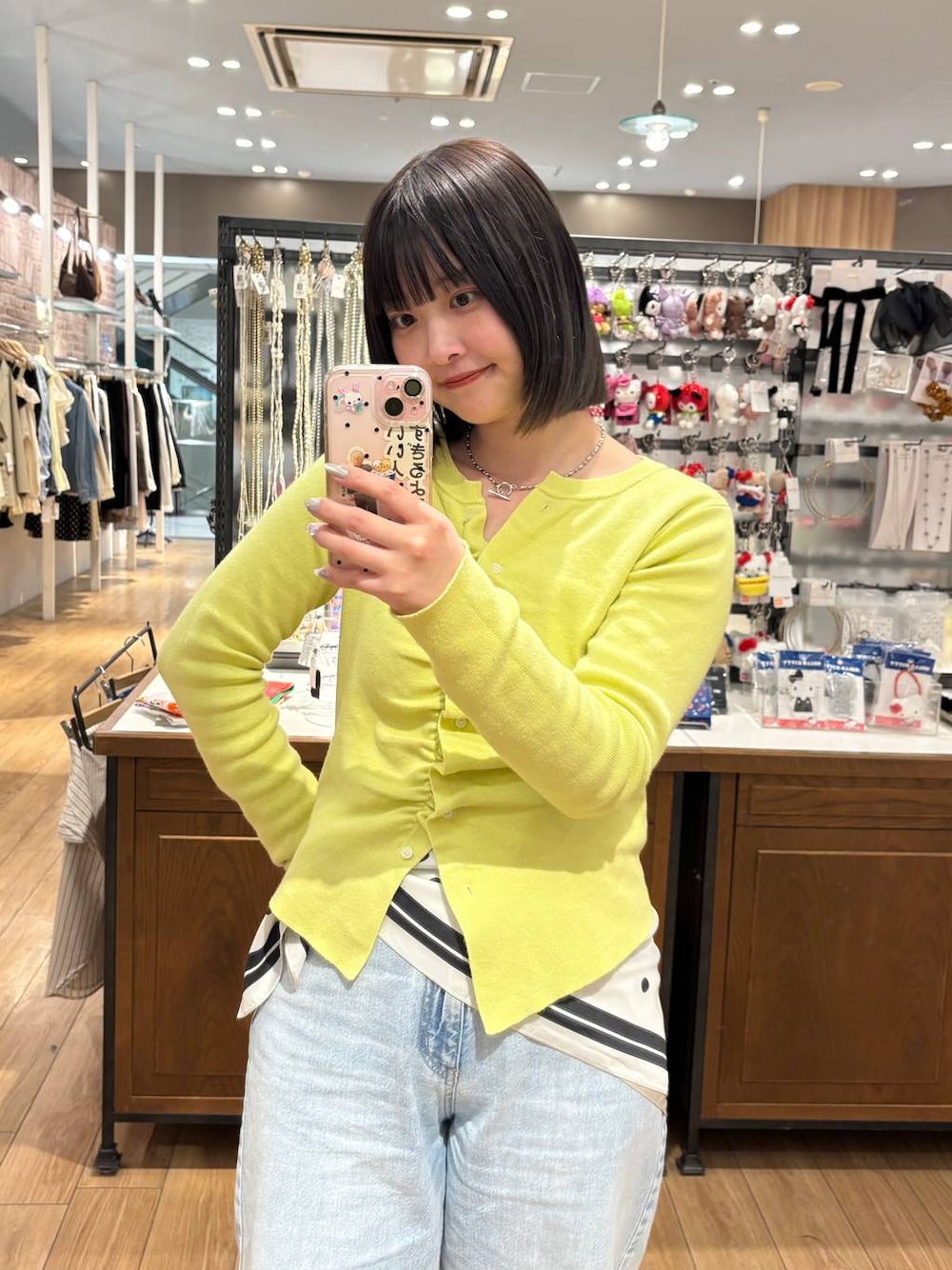 ブルー系のデニムパンツ、ブラウン系のローファー、イエロー系のカーディガン/ボレロを着用したレディースの春コーディネートの1枚目の写真