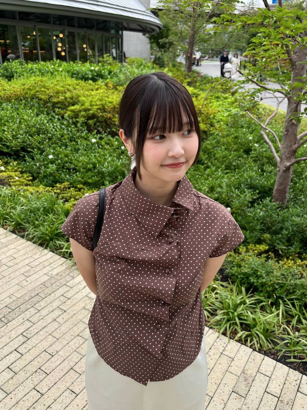 ホワイト系のスカート、ブラック系のサンダル、ブラック系のボディバッグ/ウエストポーチを着用したレディースの夏コーディネートの1枚目の写真
