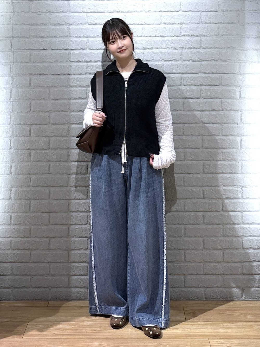 ブラウン系のバレエシューズ、ホワイト系のTシャツ/カットソー、ブラック系のベストを着用したレディースの秋コーディネートの1枚目の写真
