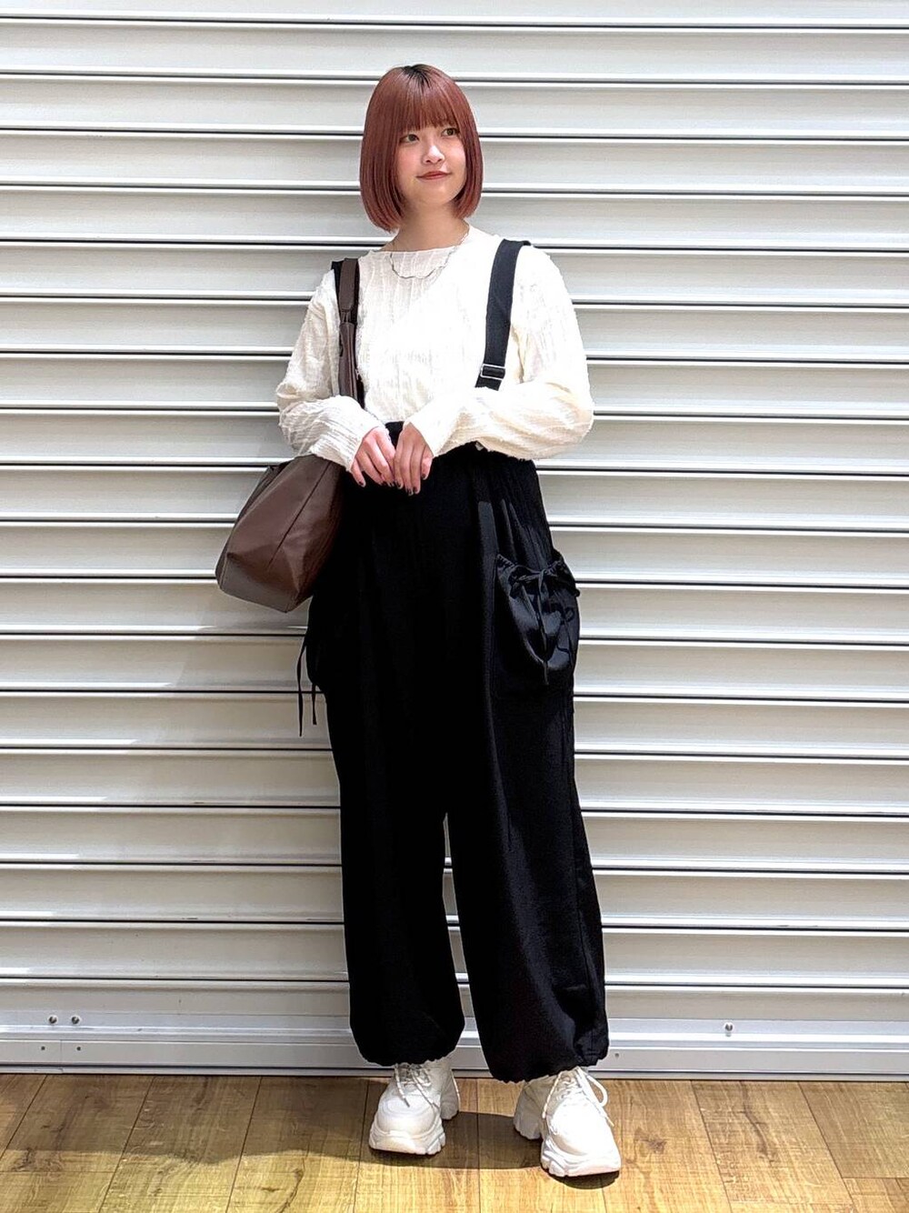 ベージュ系のTシャツ/カットソー、ホワイト系のスニーカー、ブラウン系のトートバッグを着用したレディースの春コーディネートの1枚目の写真