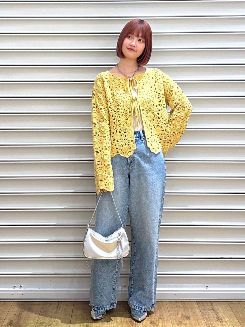 ブルー系のデニムパンツ、ゴールド系のタンクトップ、シルバー系のトートバッグを着用したレディースの春コーディネートの1枚目の写真