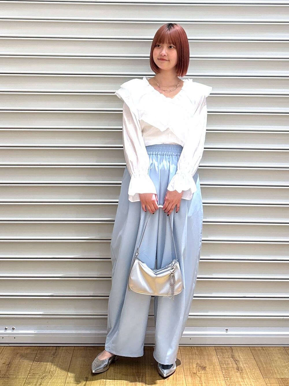 シルバー系のトートバッグ、シルバー系のパンプス、ホワイト系のシャツ/ブラウスを着用したレディースの春コーディネートの1枚目の写真
