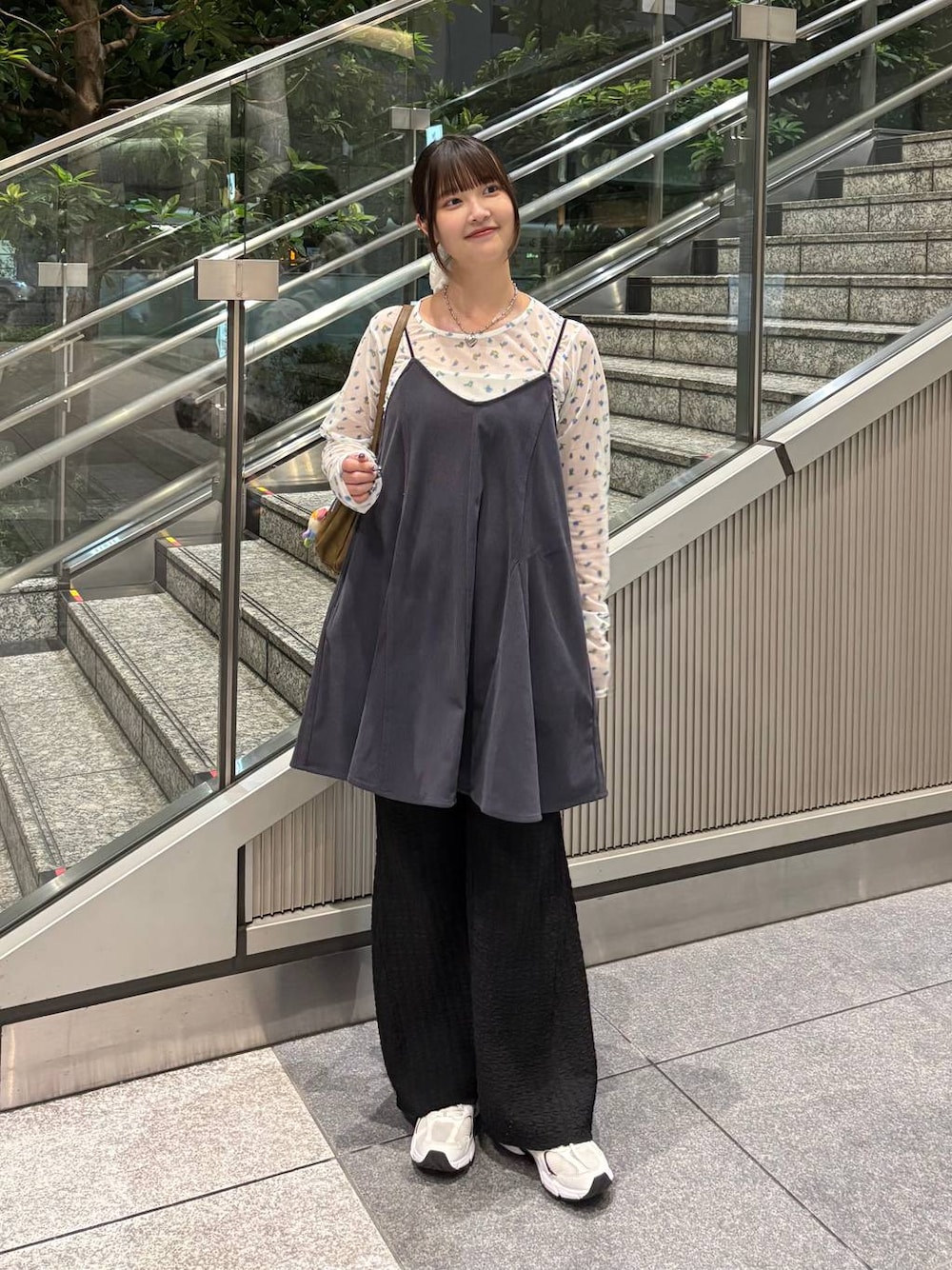 グレー系のスカート、ホワイト系のTシャツ/カットソー、ブラック系のその他パンツを着用したレディースの秋コーディネートの1枚目の写真