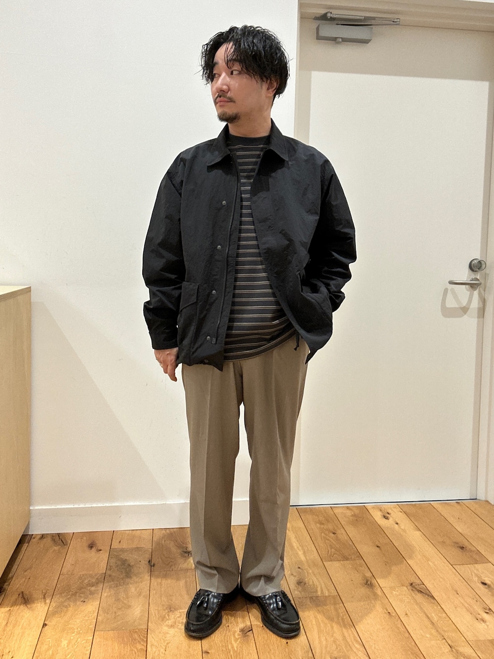 グレー系のTシャツ/カットソー、ブラック系のナイロンジャケット、ベージュ系のその他パンツを着用したメンズの冬コーディネートの1枚目の写真