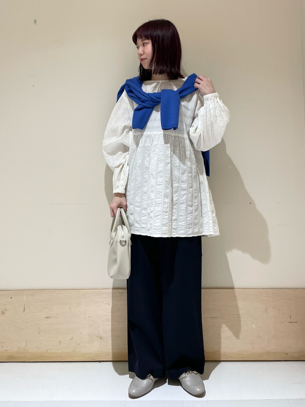 ブルー系のその他パンツ、ホワイト系のシャツ/ブラウス、ブルー系のニット/セーターを着用したレディースの春コーディネートの1枚目の写真