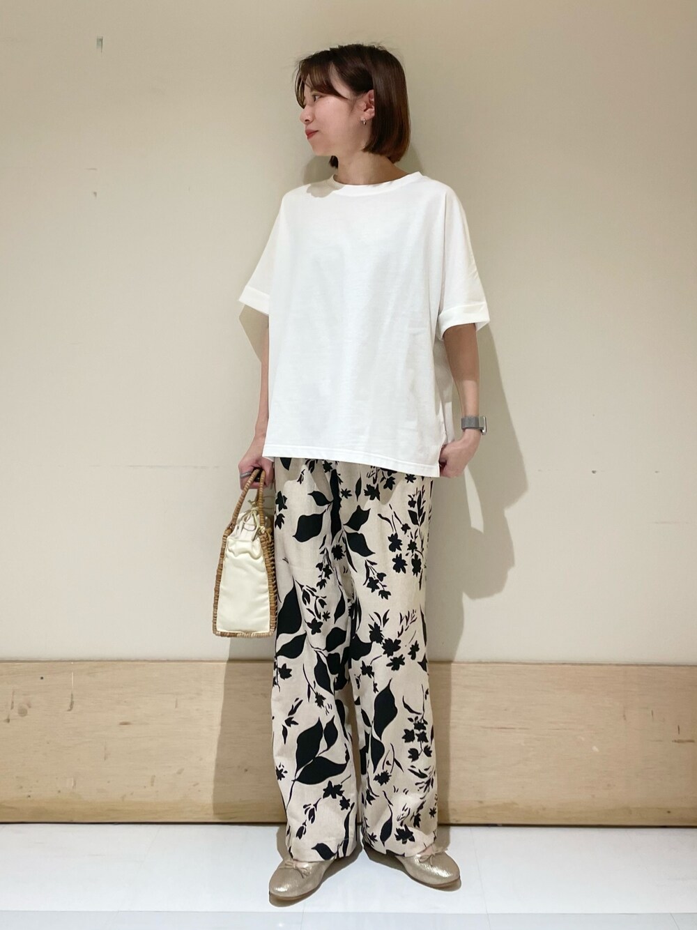 ベージュ系のその他パンツ、ホワイト系のTシャツ/カットソー、ベージュ系のハンドバッグを着用したレディースの夏コーディネートの1枚目の写真