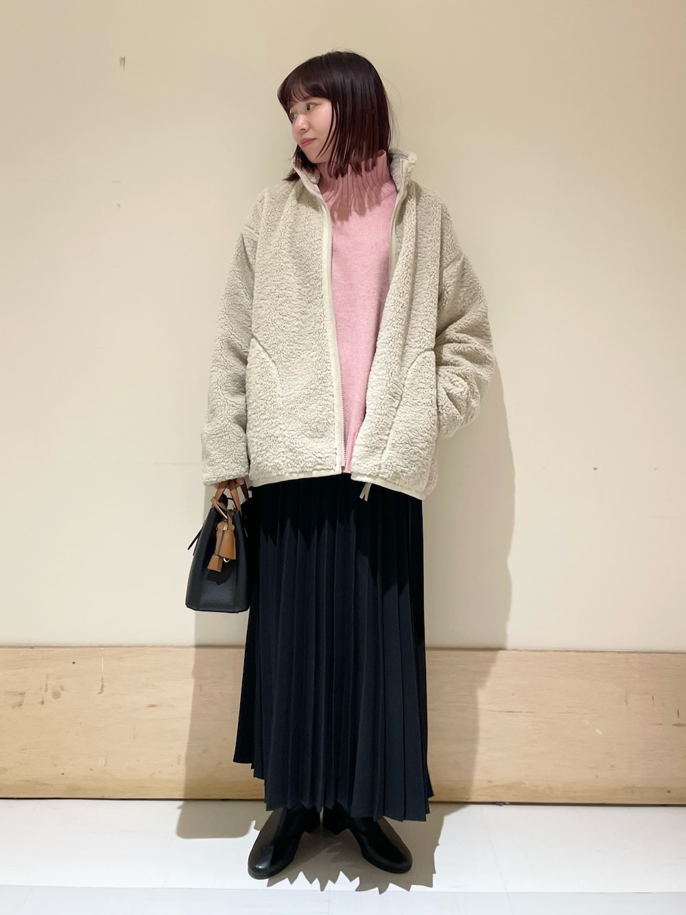 ピンク系のニット/セーター、ホワイト系のブルゾン、ブラック系のスカートを着用したレディースの冬コーディネートの1枚目の写真