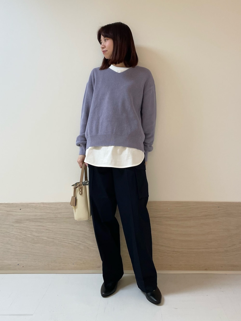 パープル系のニット/セーター、ホワイト系のTシャツ/カットソー、ブルー系のカーゴパンツを着用したレディースの春コーディネートの1枚目の写真