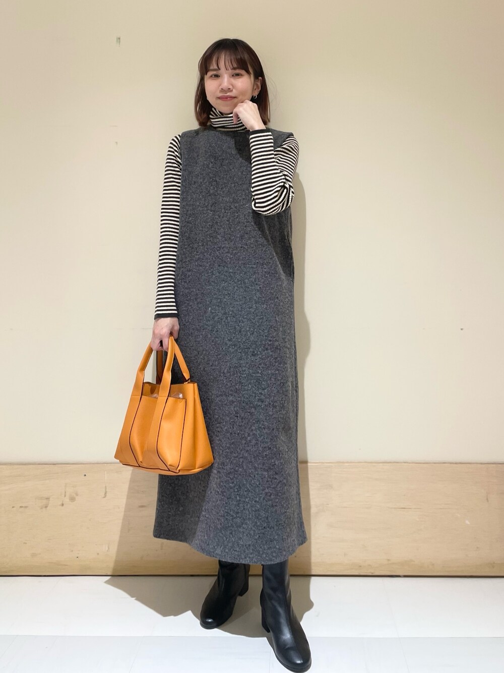 ホワイト系のニット/セーター、グレー系のワンピースを着用したレディースの冬コーディネートの1枚目の写真