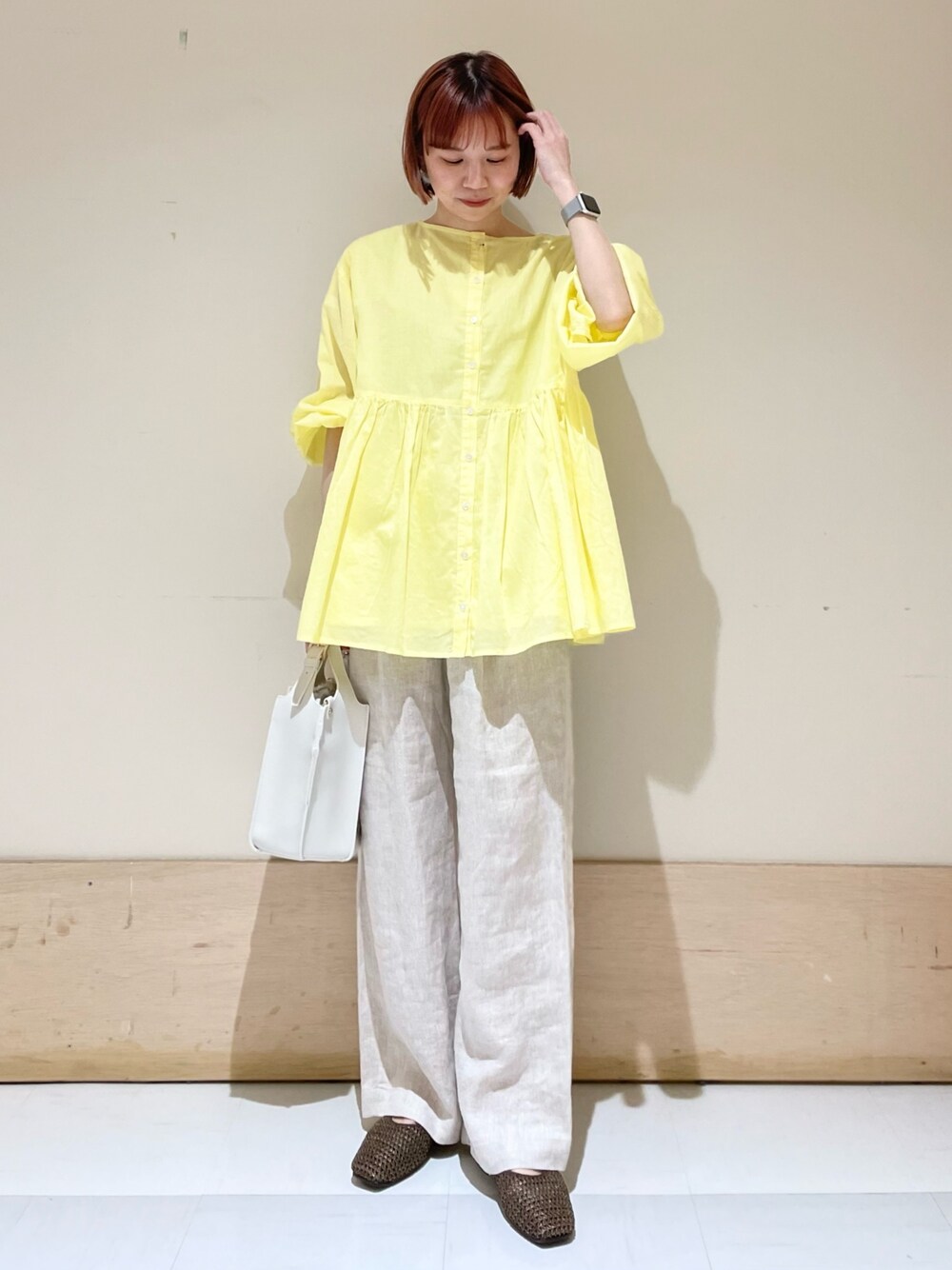 ベージュ系のその他パンツ、イエロー系のシャツ/ブラウス、ホワイト系のトートバッグを着用したレディースの春コーディネートの1枚目の写真