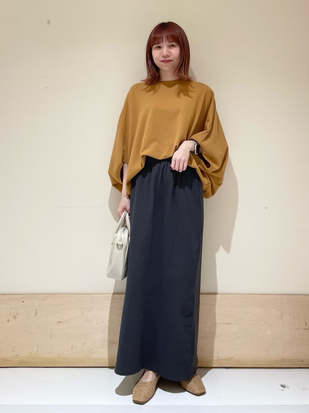 イエロー系のTシャツ/カットソー、ベージュ系のパンプス、グレー系のスカートを着用したレディースの春コーディネートの1枚目の写真