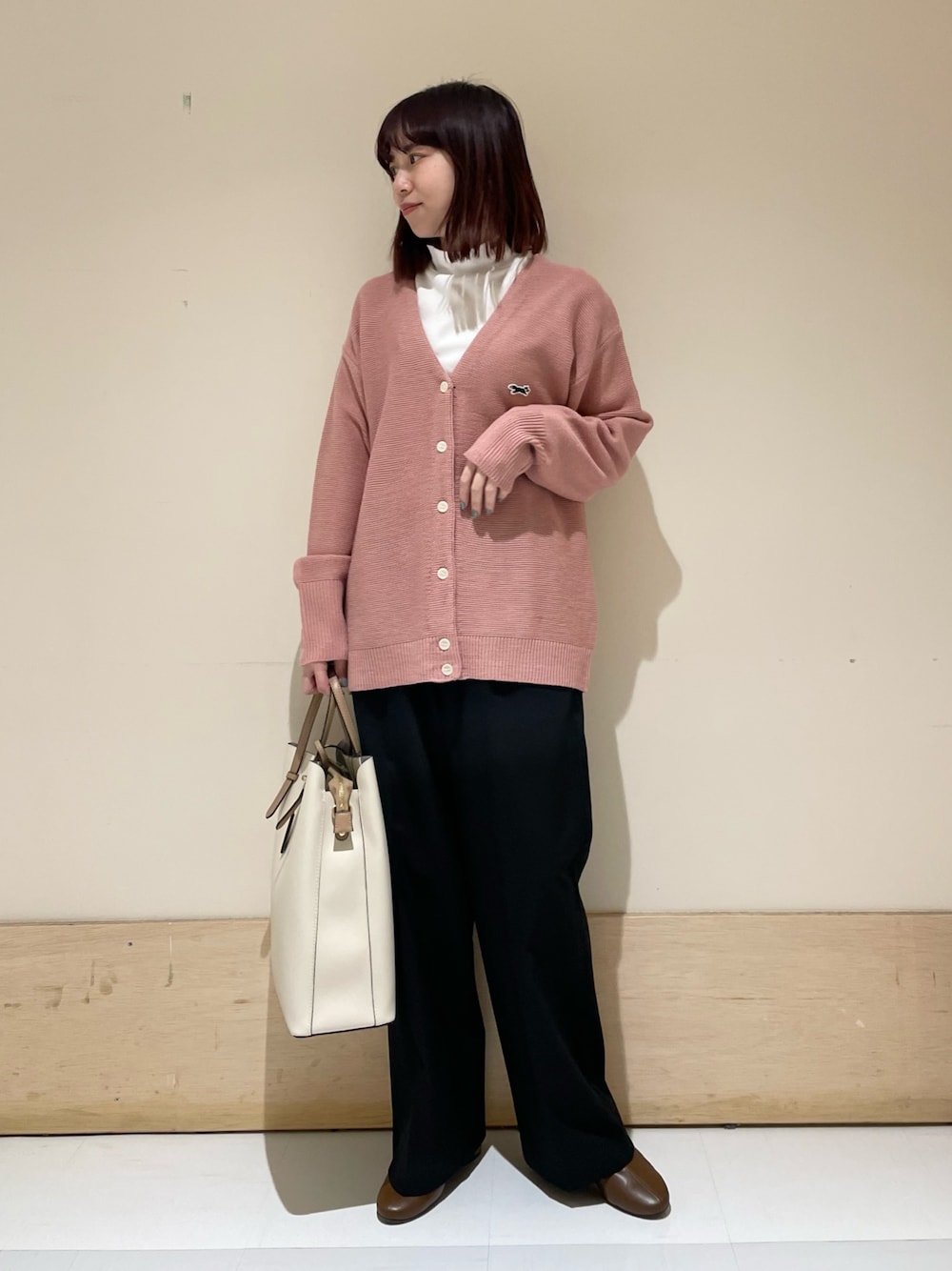 ピンク系のカーディガン/ボレロ、ホワイト系のTシャツ/カットソー、ブラック系のその他パンツを着用したレディースの冬コーディネートの1枚目の写真