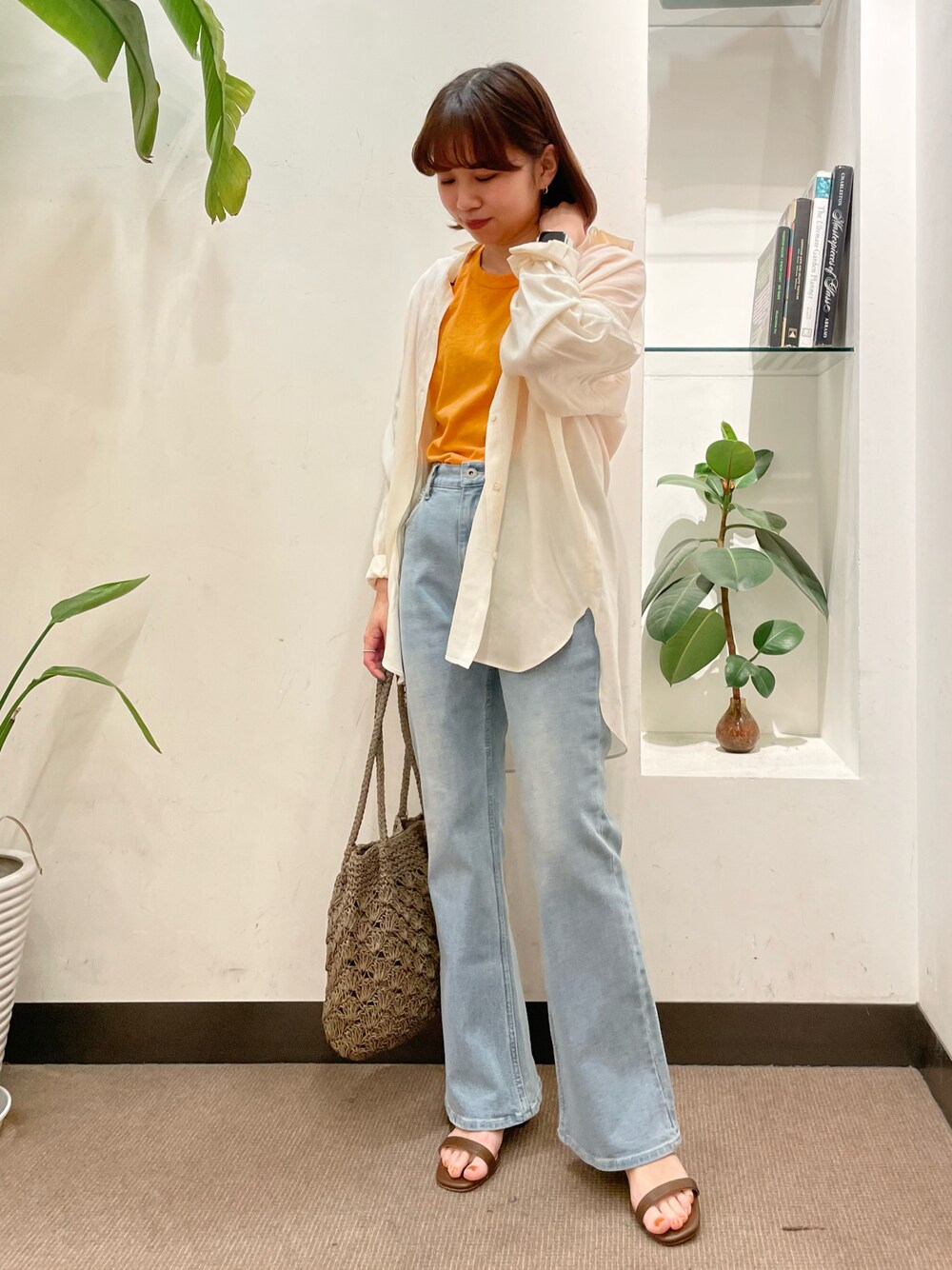 ブルー系のデニムパンツ、ホワイト系のシャツ/ブラウス、オレンジ系のTシャツ/カットソーを着用したレディースの春コーディネートの1枚目の写真