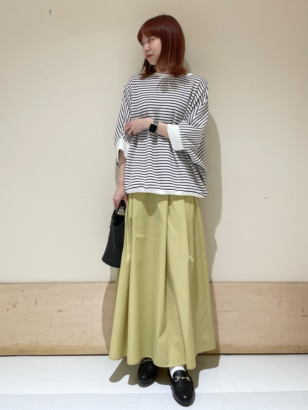 ホワイト系のTシャツ/カットソー、イエロー系のスカート、ブラック系のローファーを着用したレディースの春コーディネートの1枚目の写真