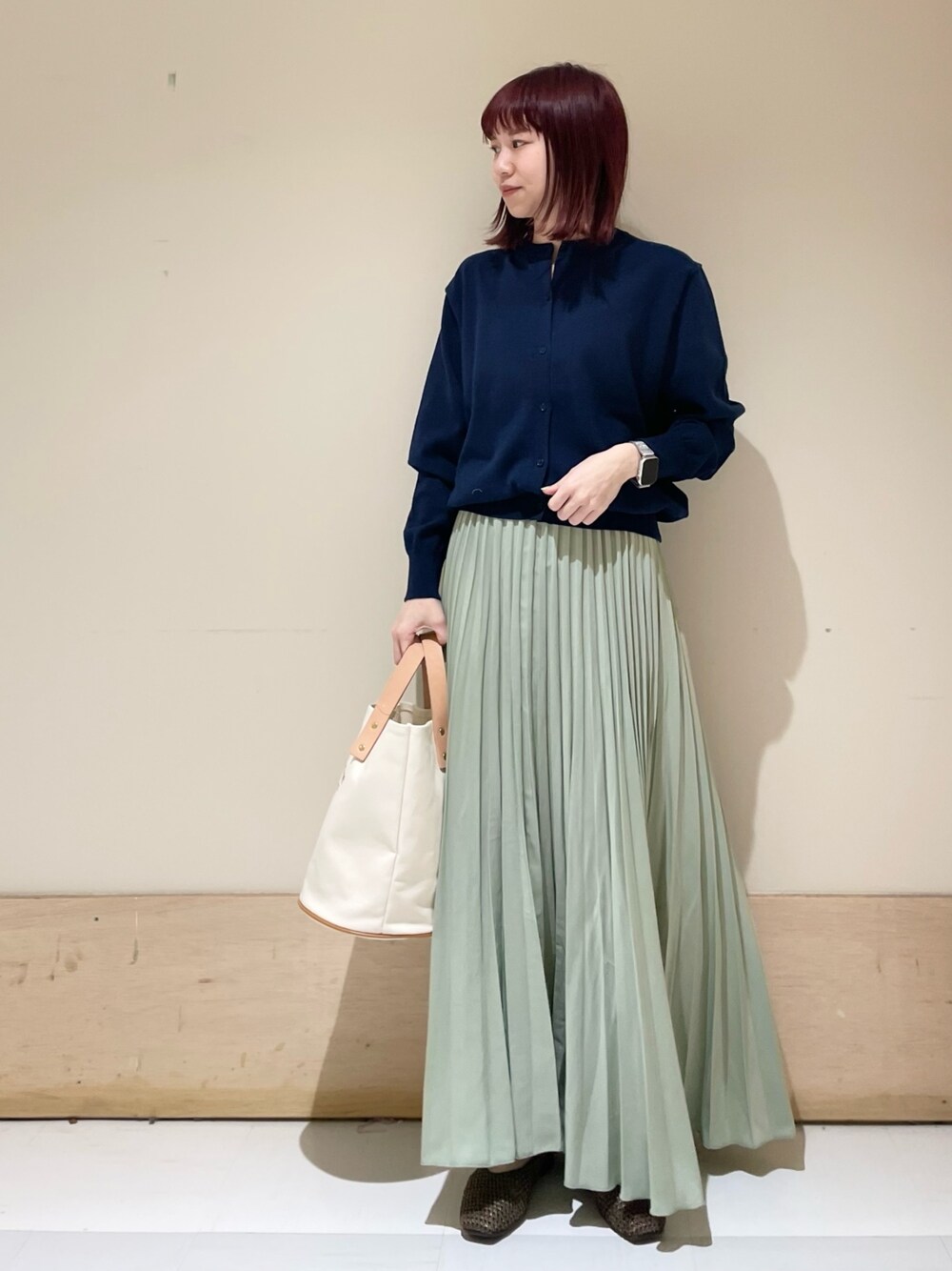 ブルー系のカーディガン/ボレロ、ブラウン系のパンプス、ホワイト系のトートバッグを着用したレディースの春コーディネートの1枚目の写真