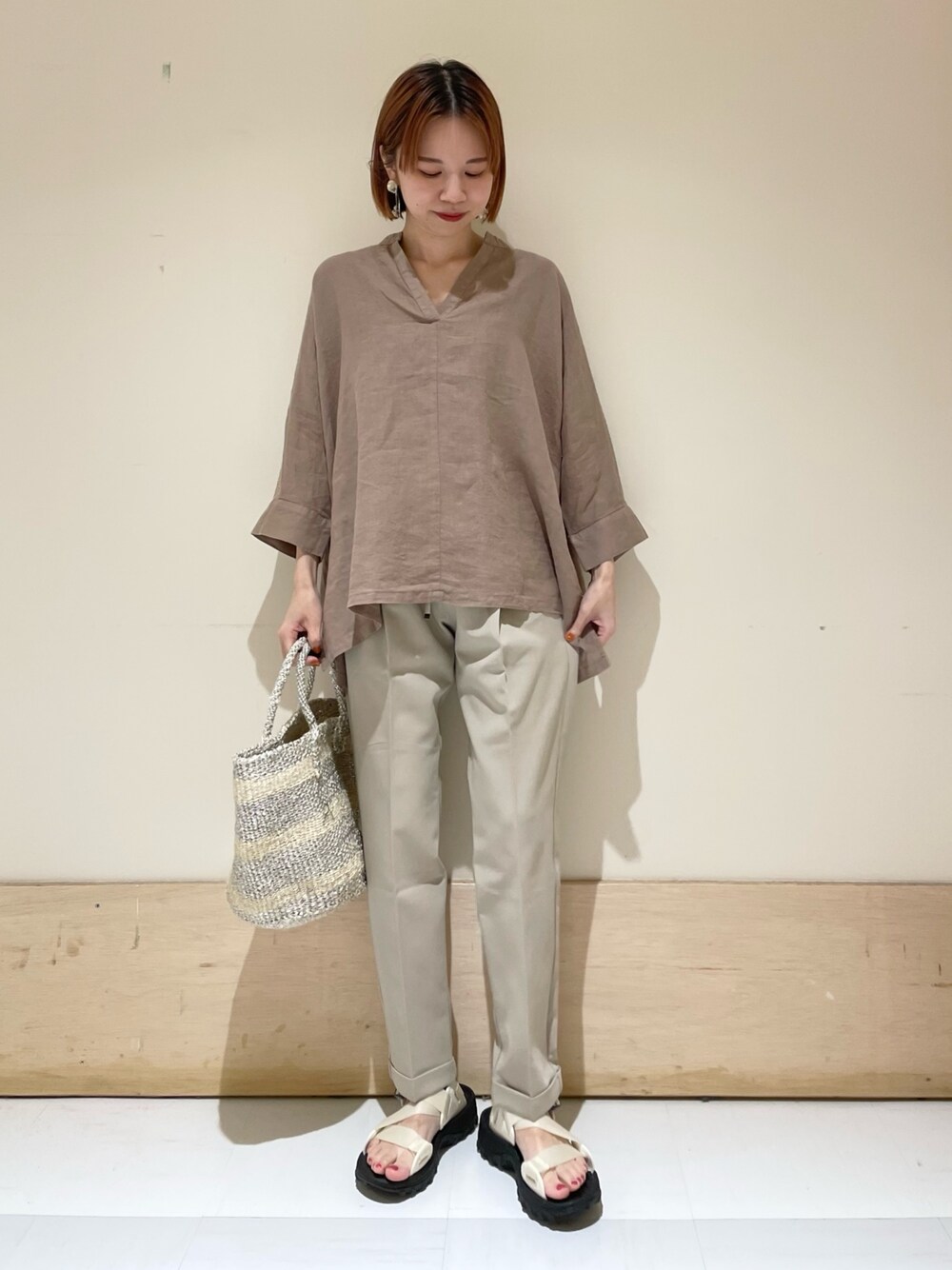 ベージュ系のその他パンツ、ホワイト系のハンドバッグ、ホワイト系のサンダルを着用したレディースの夏コーディネートの1枚目の写真