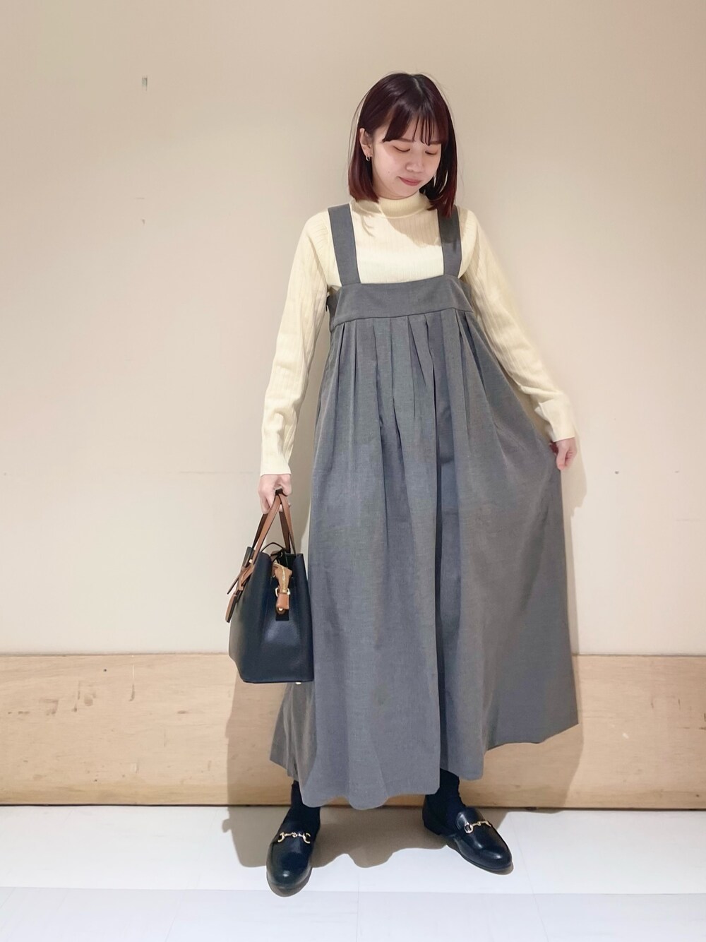 グレー系のワンピース、ホワイト系のニット/セーターを着用したレディースの冬コーディネートの1枚目の写真
